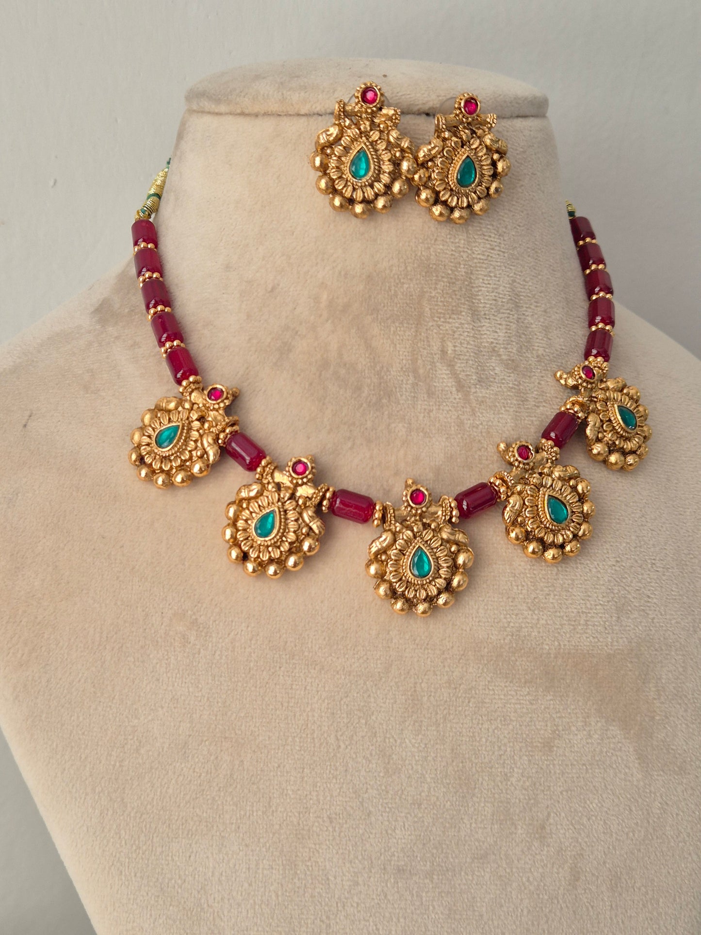 Antique gold-plated red bead necklace set embellished with turquoise-green stone pendants and matching stud earrings