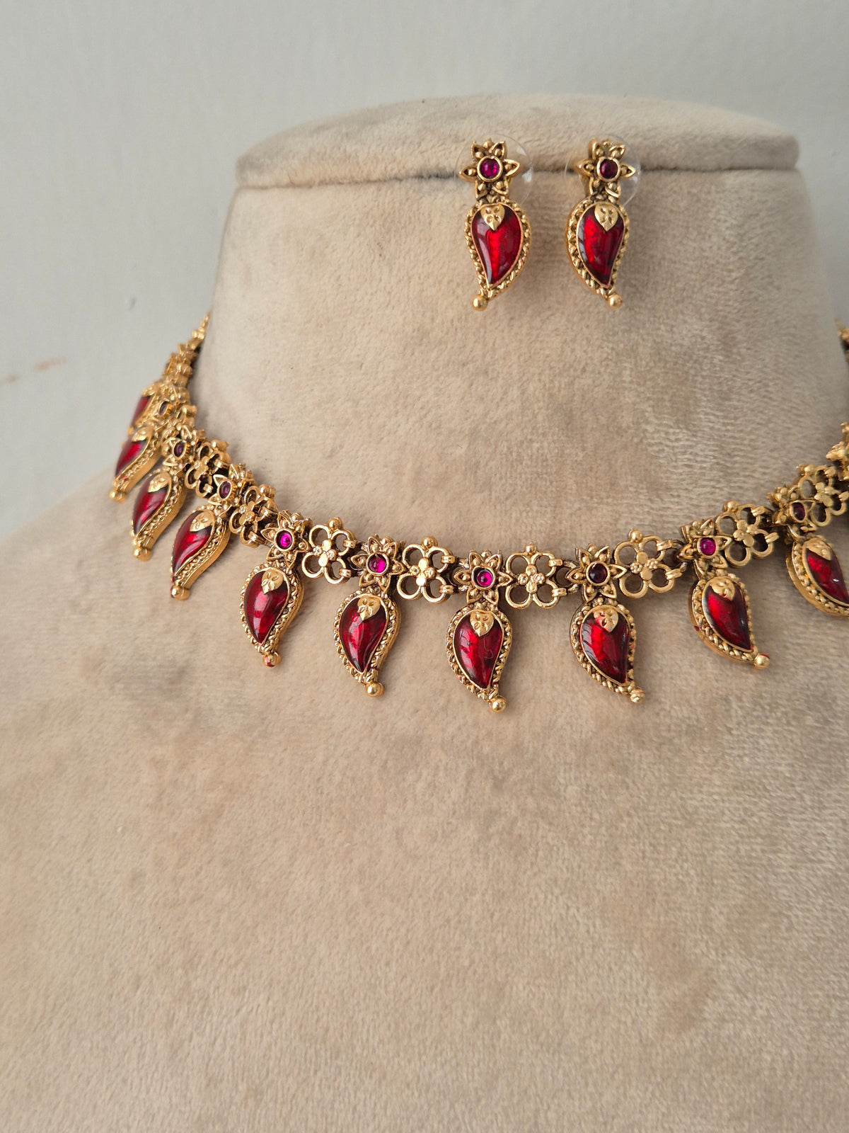 Antique gold-plated choker necklace set embellished with ruby-red teardrop stones and matching drop earrings