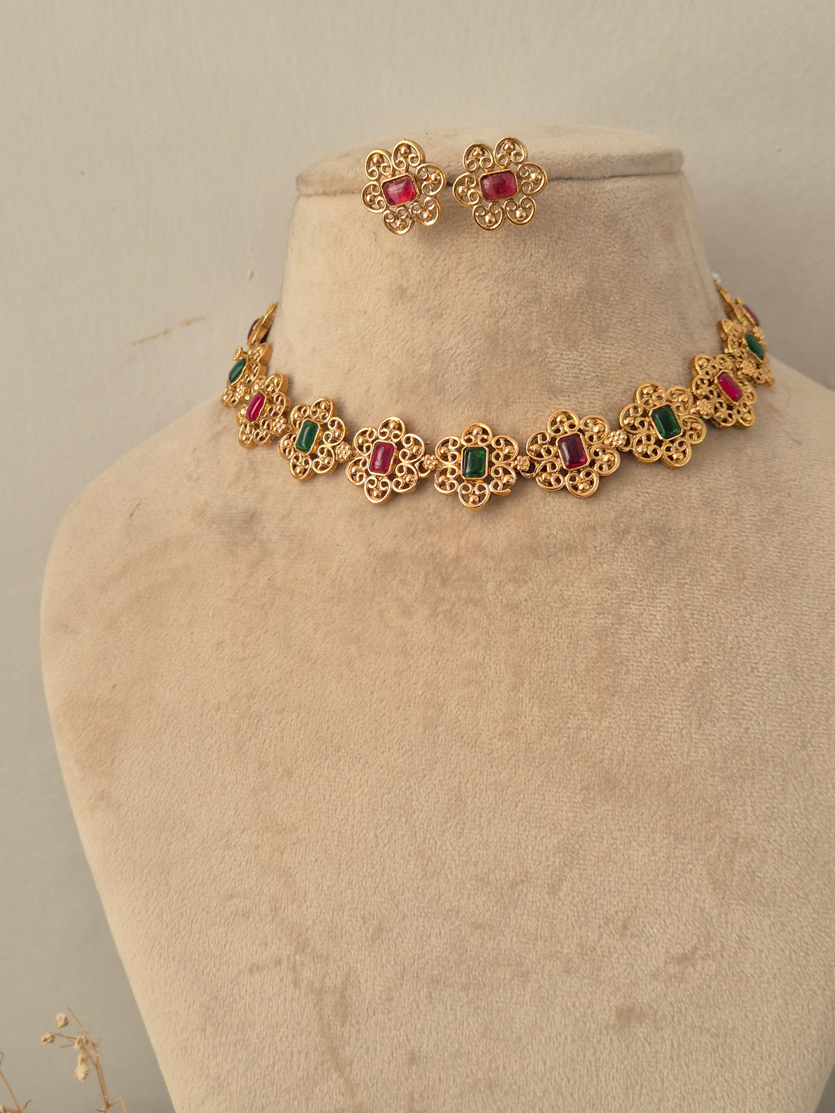 Traditional gold filigree floral necklace set with red and green stones and matching stud earrings