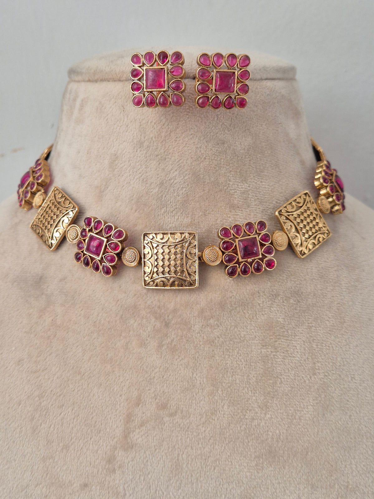 Antique gold-plated geometric choker necklace set with ruby-pink stone embellishments and coordinating stud earrings