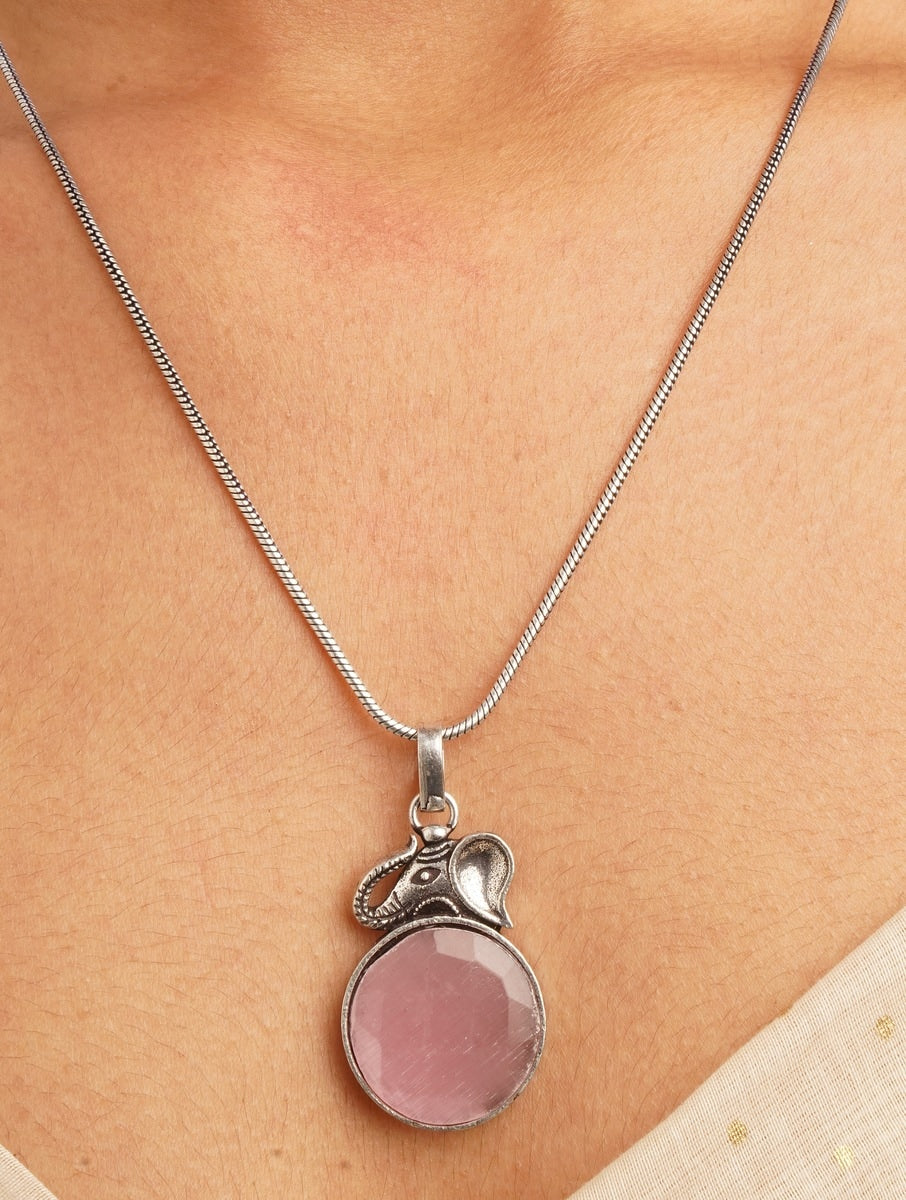 Pink and silver necklace, earrings, ring set on soft background