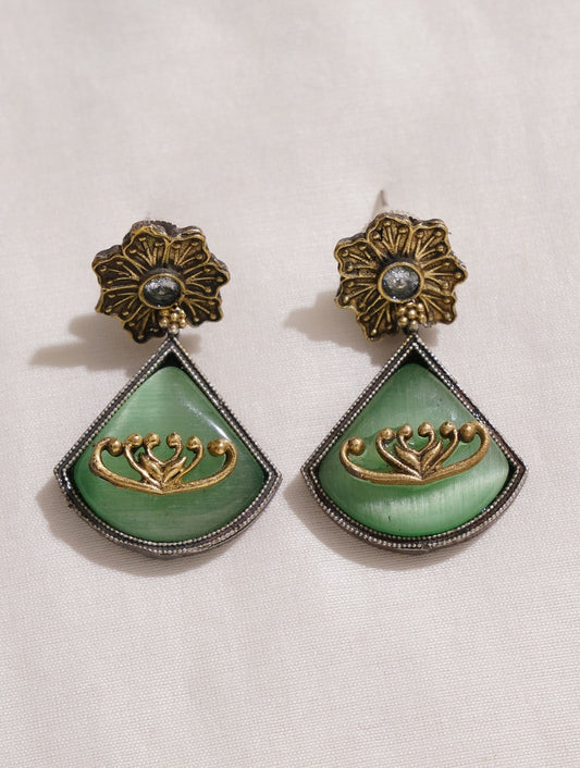 Dual-tone green and red brass dangle earrings on minimalist backdrop