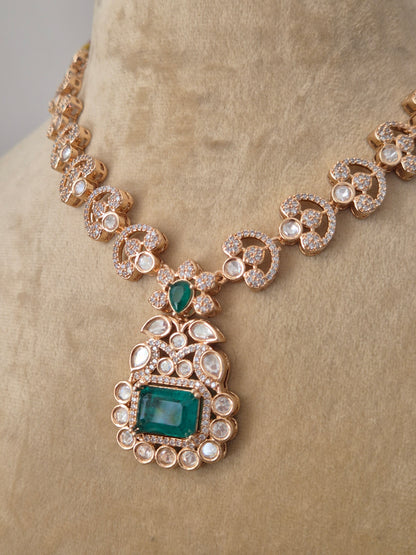 Rose-Gold toned necklace with a large emerald green pendant surrounded by clear crystals by naitri.in