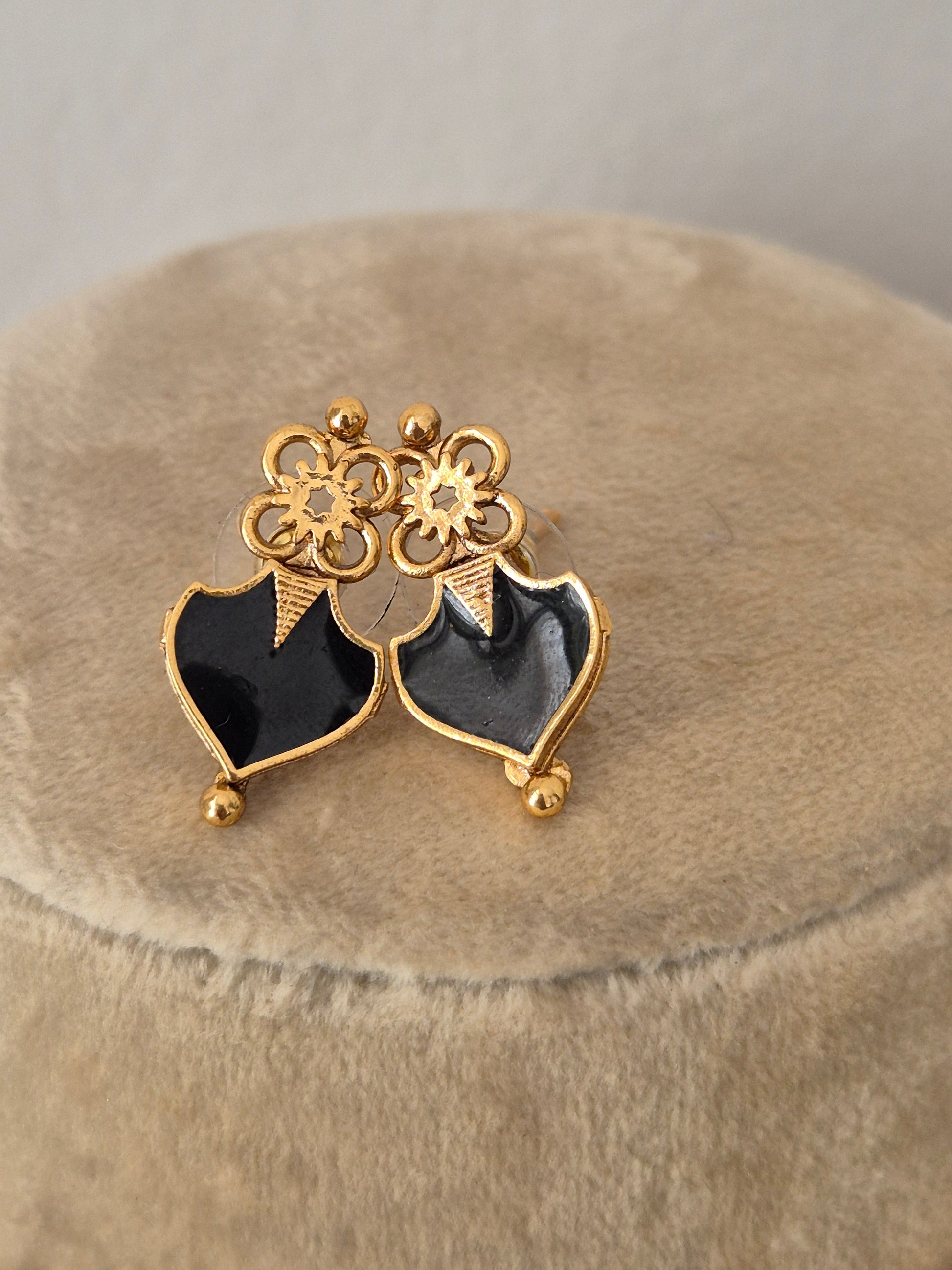 golden brass alloy earrings  a repeating pattern of black heart-shaped gemstone charms stud earrings by naitri.in