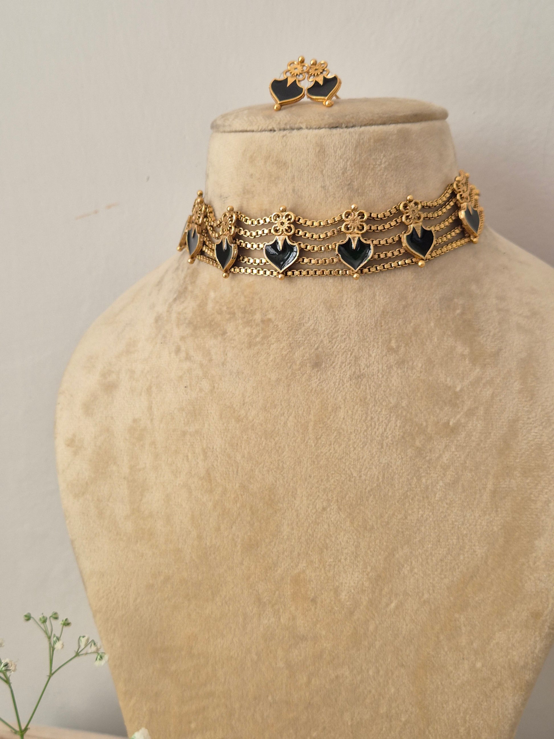 legant black and gold-toned traditional choker jewelry set Naitri gold-plated Aahana choker and earring set with black gemstone details by naitri.in