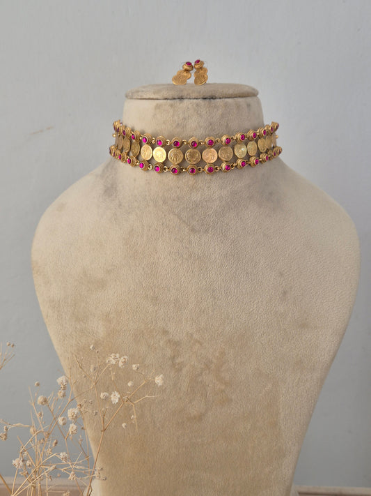 Aakhi golden choker necklace set with ruby-colored stone accents and matching stud earrings by Naitri.in