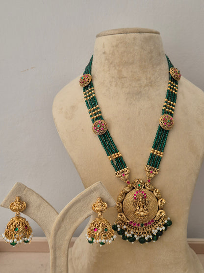 A gold-plated multi-strand green beaded temple jewelry necklace featuring a large round pendant with goddess engravings by naitri.in