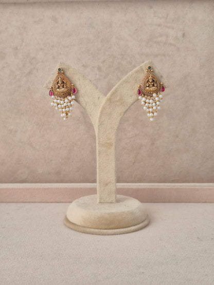 Handcrafted gold-plated jhumki earrings featuring intricate traditional metalwork and hanging pearl bead accents by Naitri.in