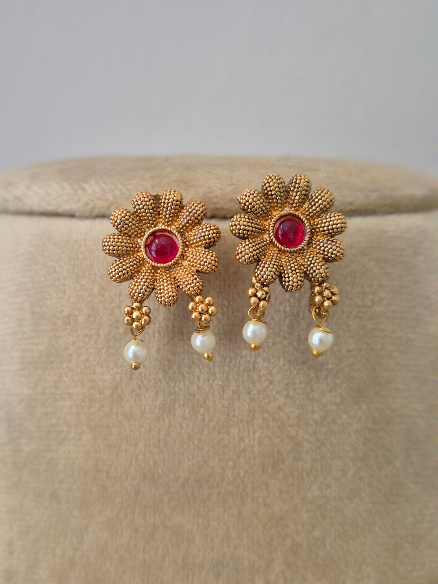 Handcrafted brass alloy earrings and ruby-red floral embellishments and delicate golden flowers by naitri.in