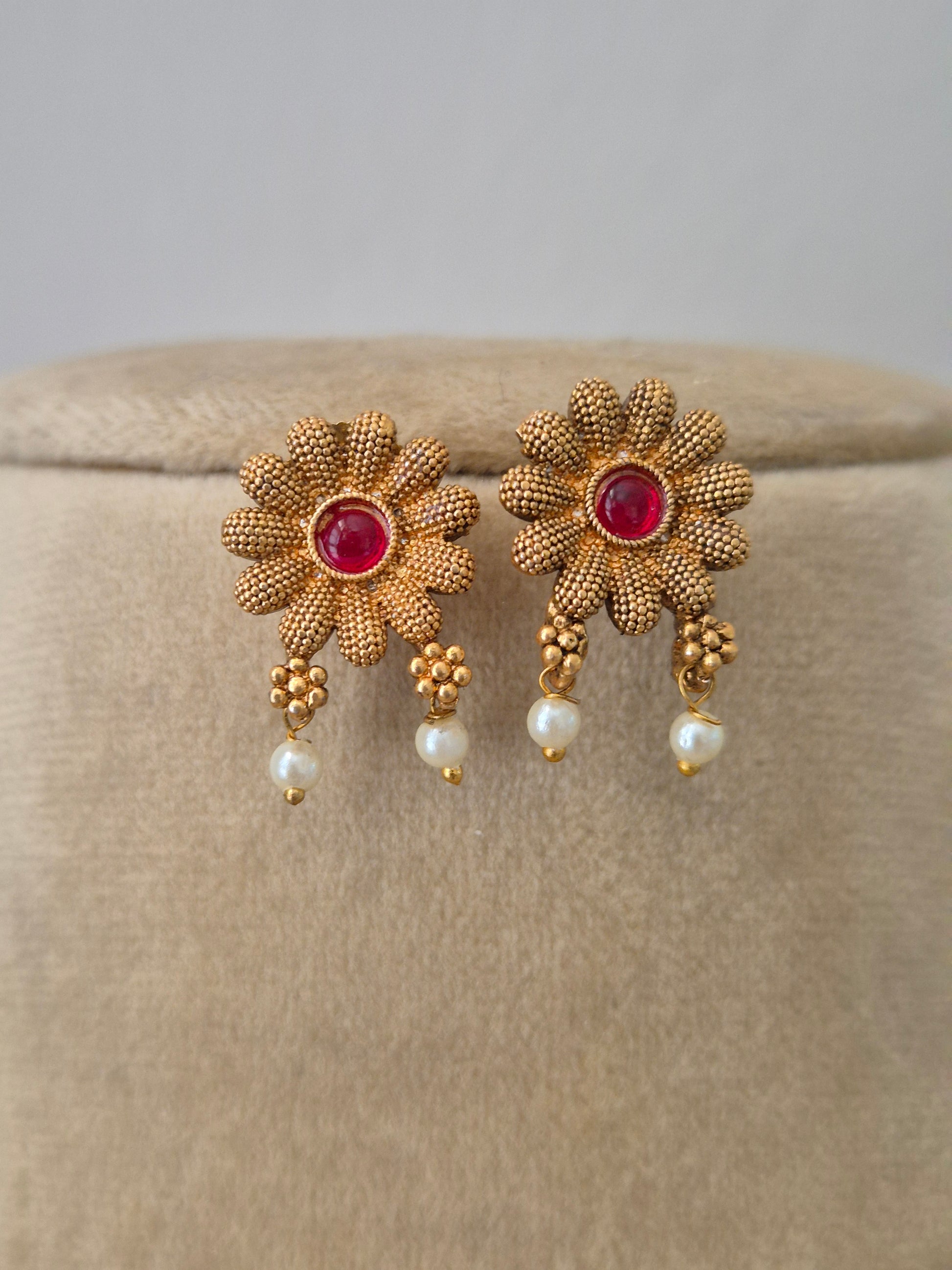 Handcrafted brass alloy earrings and ruby-red floral embellishments and delicate golden flowers by naitri.in