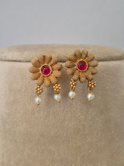 Handcrafted brass alloy earrings and ruby-red floral embellishments and delicate golden flowers by naitri.in
