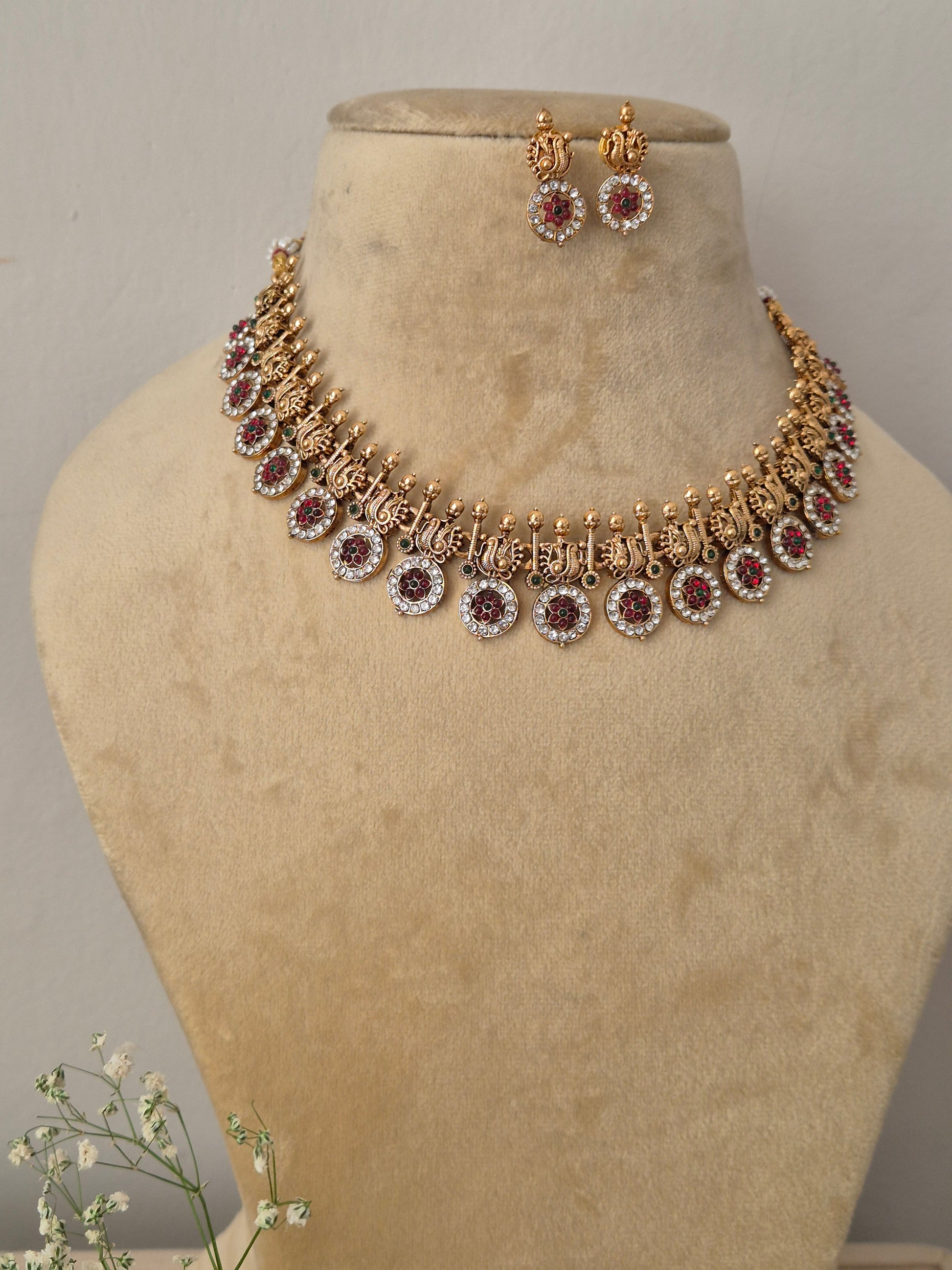 Handcrafted antique gold statement jewelry set showcasing intricate metallic engravings and crystal embellishments, by naitri.in