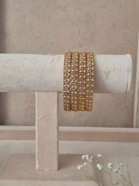 Set of 4 Aaravi gold bangles by Naitri featuring intricate traditional textured engravings, by naitri.in
