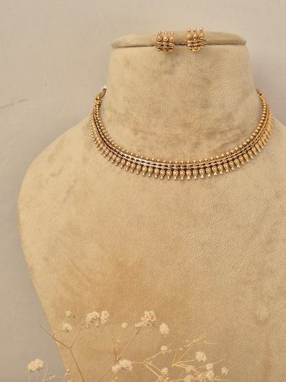Detailed close-up of textured gold necklace by naitri.in