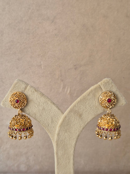 Gold-plated Jhumki earrings with red stones and hanging bead details raditional gold-plated Jhumka earrings with red gemstones and bead dangles by naitri.in