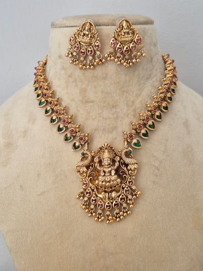 Elegant traditional gold-toned ethnic necklace set with intricate religious motif carvings, by naitri.in