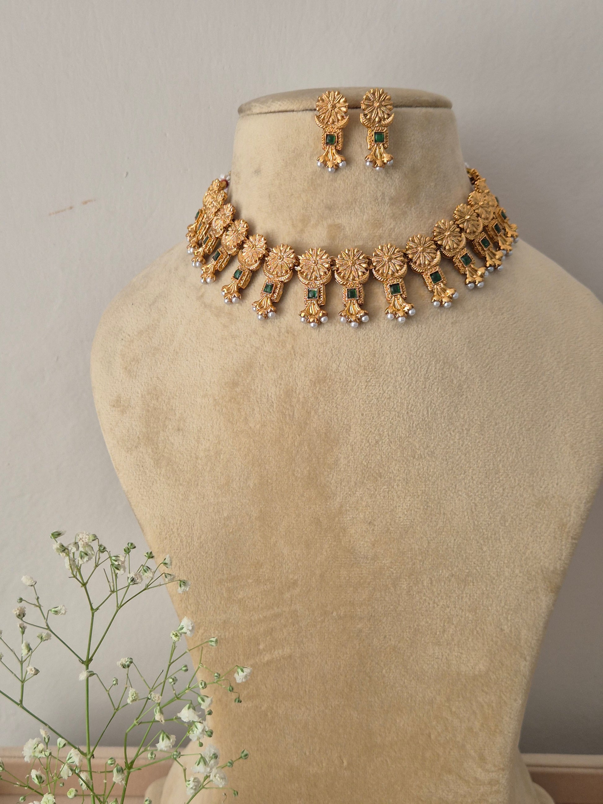 Antique gold choker necklace with matching drop earrings and small green gemstones with matching earrings by naitri.in