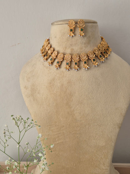 Antique gold choker necklace with matching drop earrings and small green gemstones with matching earrings by naitri.in