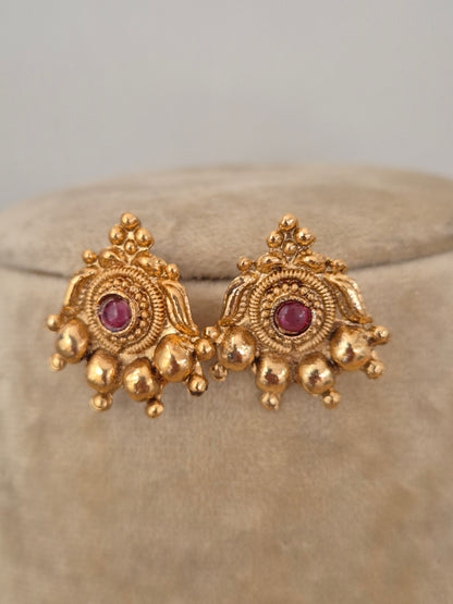 Handcrafted gold stud earrings featuring red and green stones with gold bead fringes by naitri.in
