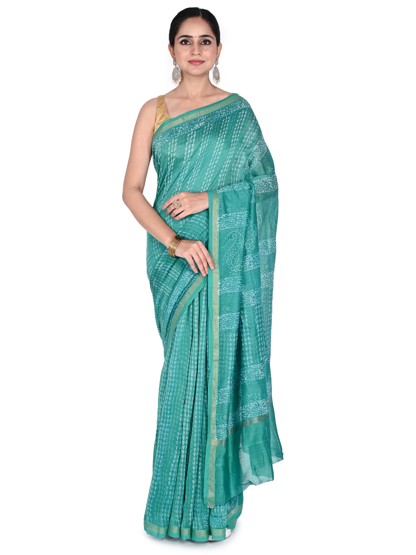 A woman wearing the Advita teal green hand block printed cotton-silk saree with a gold border, draped in a classic style by naitri.in