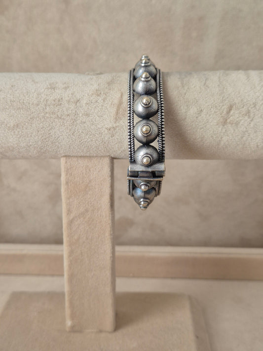 handcrafted silver oxidized Aksha bangle with intricate geometric and dome patterns by naitri.in