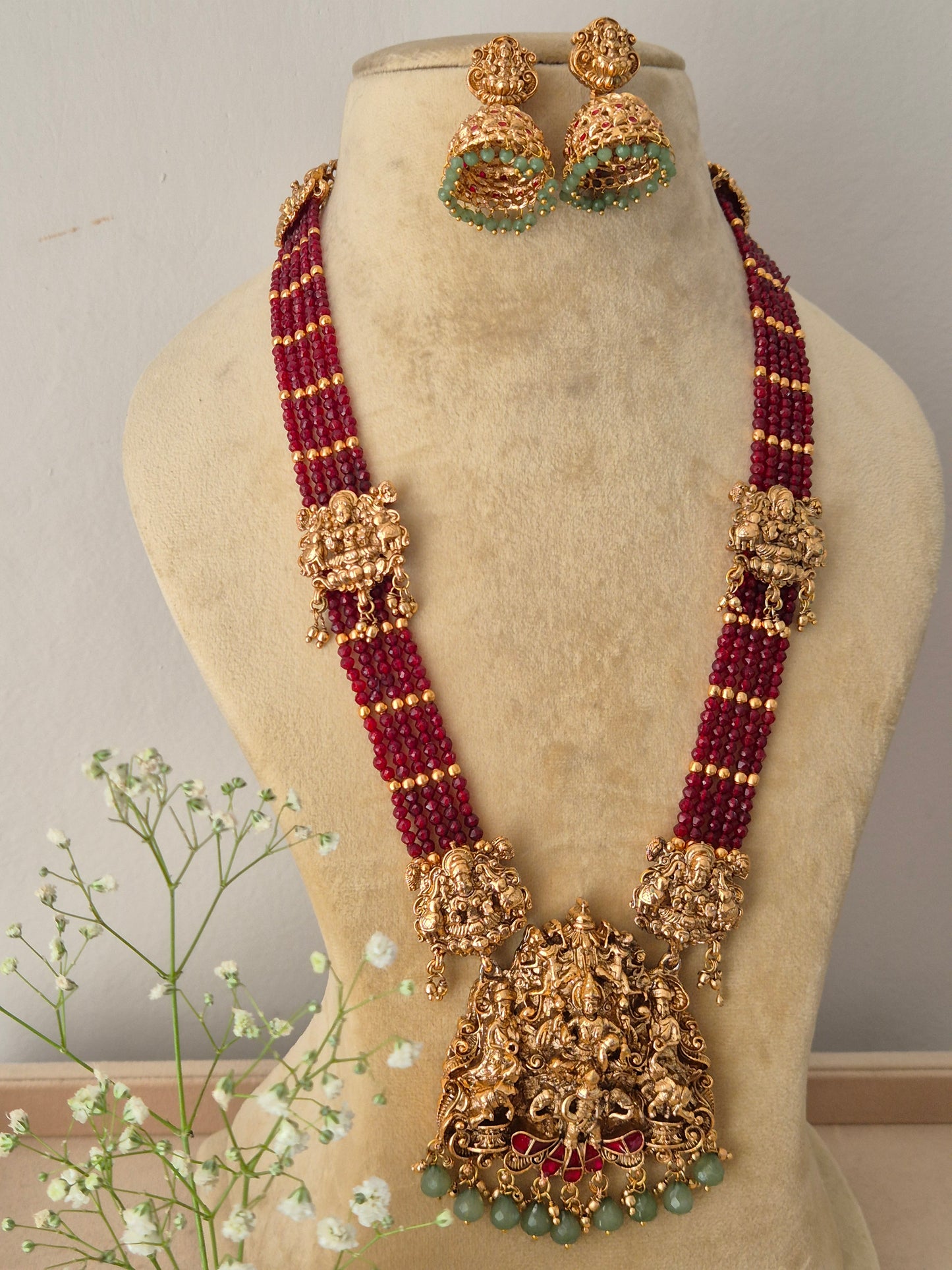Elegant traditional gold-toned ethnic jewelry set with vibrant red beaded layers, Elegant traditional gold-toned ethnic jewelry set with vibrant red beaded layers by naitri.in