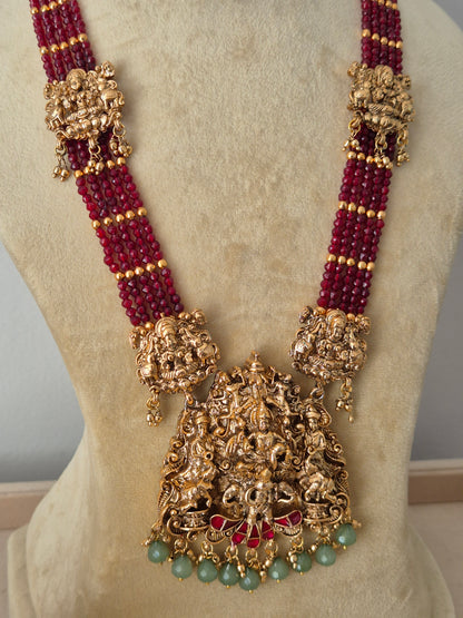 Modern Indian ethnic imitation jewelry set including a multi-layered ruby-red beaded strand necklace, a detailed gold temple pendant with hanging green beads, by naitri.in