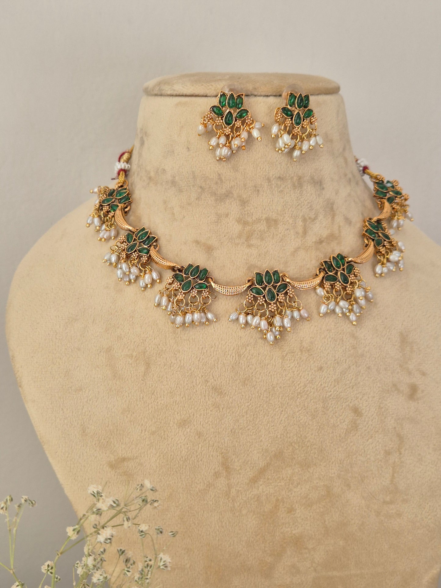 Akshara Necklace Set by Naitri featuring an ethnic gold-plated choker and matching traditional statement earrings with green stones and pearls for festive occasions by naitri.in