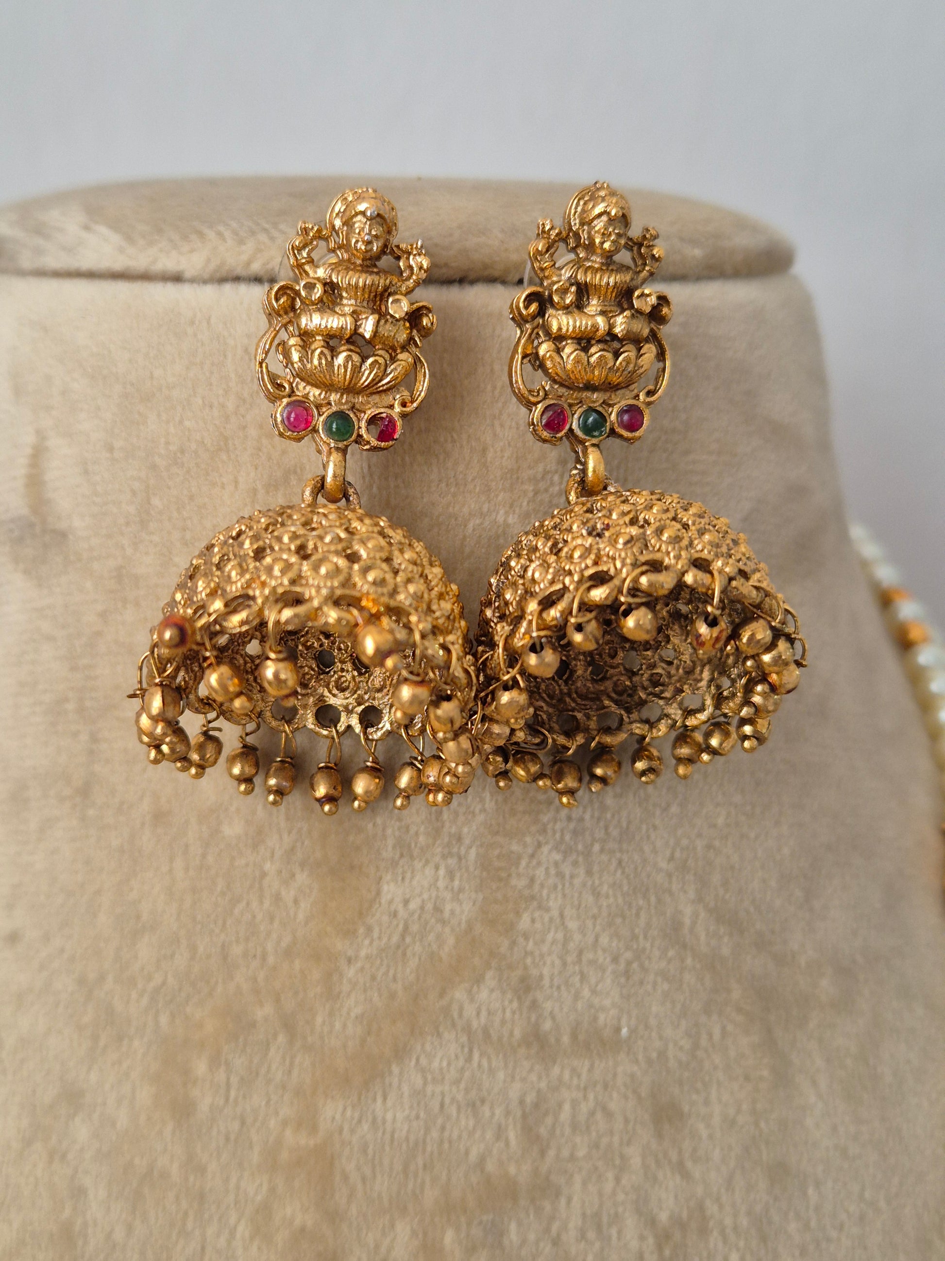 Indian style traditional heavily detailed gold-toned Lakshmi with hanging bead drops, ornate bell-shaped earrings by naitri.in