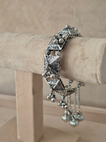Oxidized silver Alaknanda geometric bangle with dangling metallic ghungroo beads by naitri.in