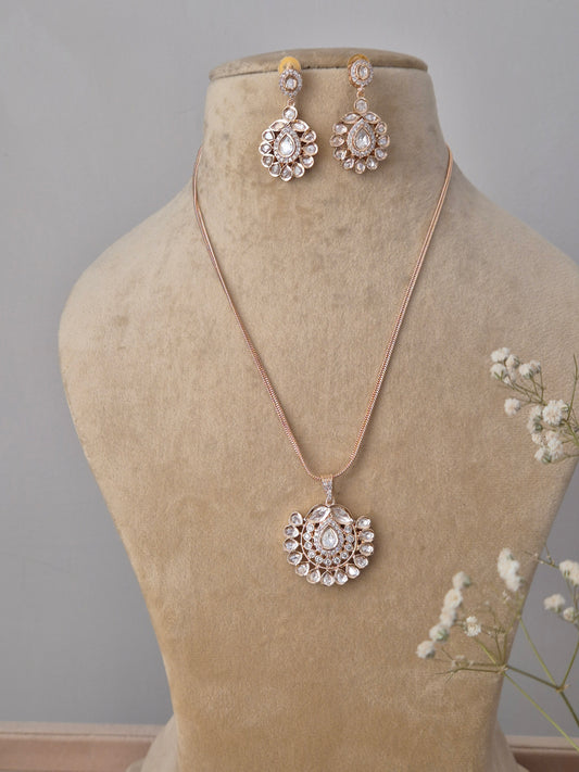 Rose gold-toned American Diamond necklace set featuring a circular floral pendant and matching drop earrings  by naitri.in