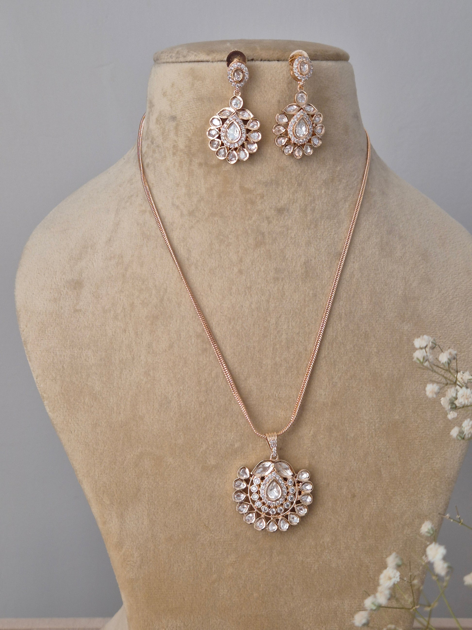American Diamond pendant necklace and drop earrings set in rose gold finish with floral motif pendant and matching earrings for festive wear by naitri.in