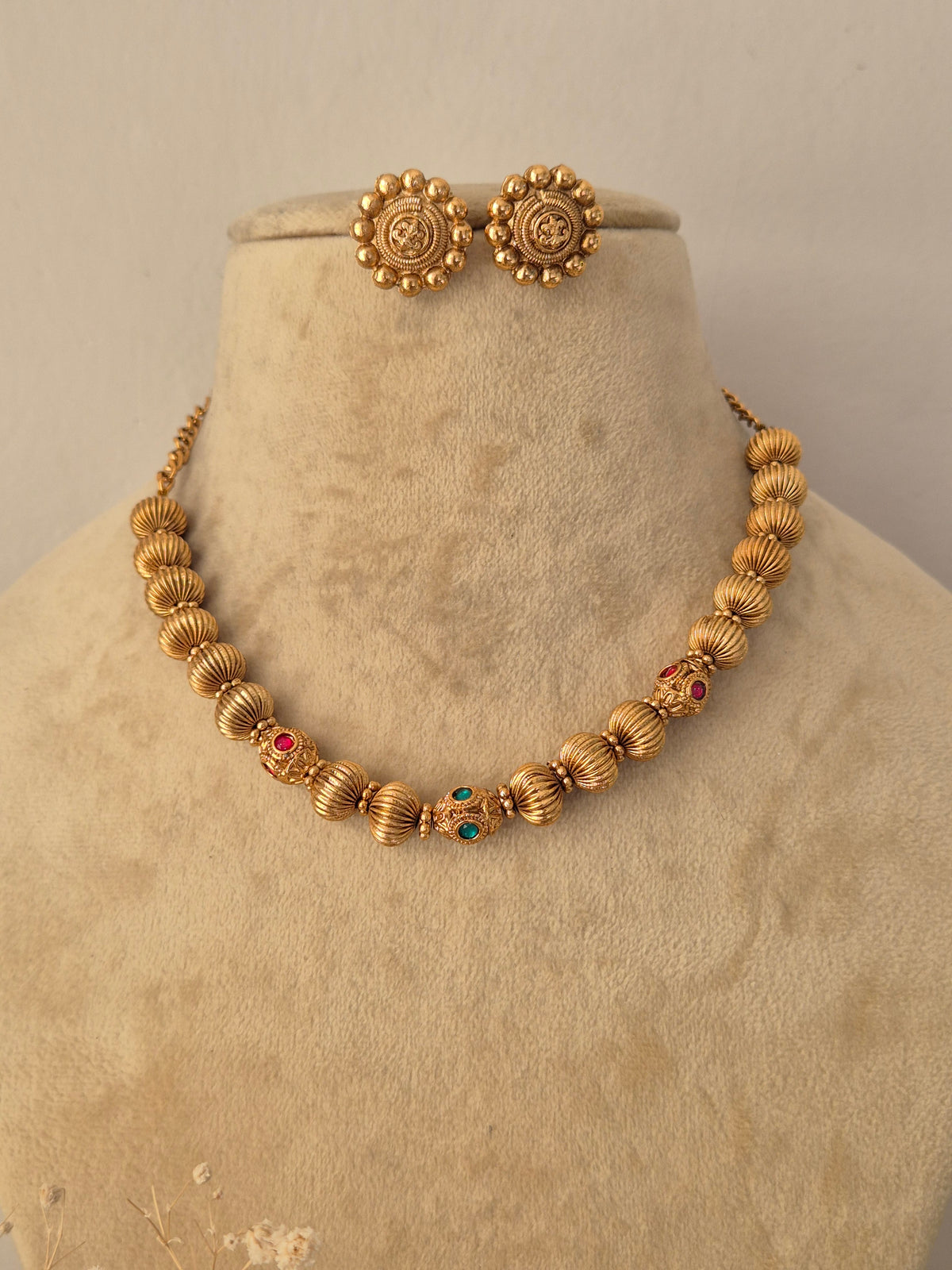 Traditional gold-toned imitation necklace with textured spherical elements and matching stud earrings by Naitri.in