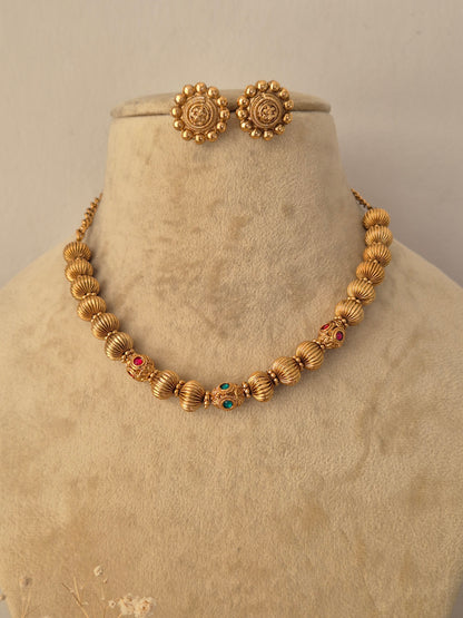 Traditional gold-toned imitation necklace with textured spherical elements and matching stud earrings by Naitri.in