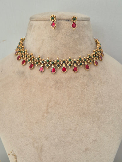 Gold choker necklace and earring set with red and green gemstone accents, Alveera Necklace Set with Red and Green Stones by naitri.in