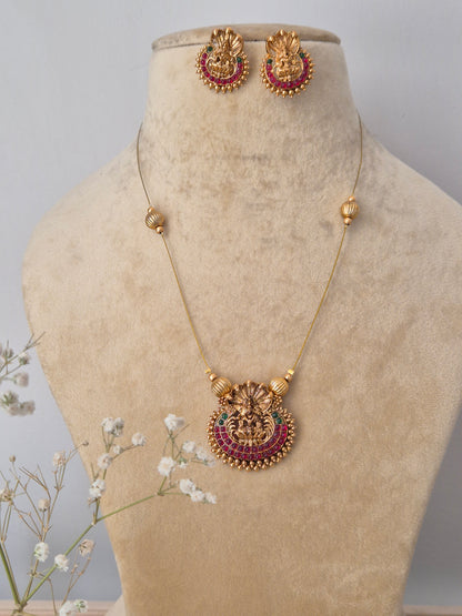 Handcrafted gold-plated brass necklace featuring a traditional Indian pendant with red stone accents and matching floral stud earrings by naitir.in