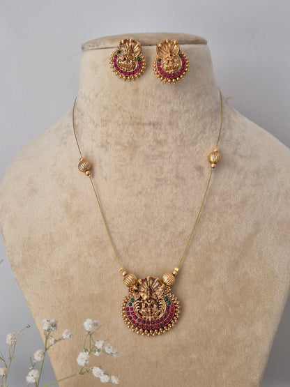 handmade Amayra necklace set from the Naitri collection, featuring a brass alloy pendant with intricate metalwork and ruby-red stones on a delicate thin chain by naitri.in