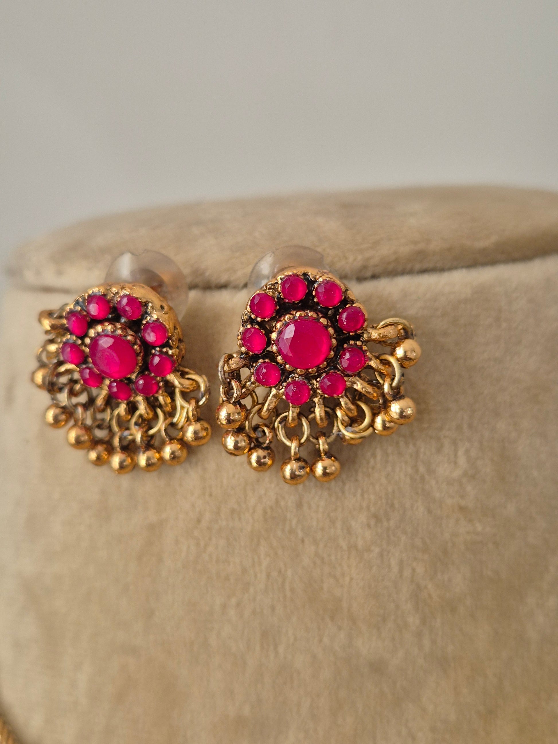 A gold minimalist chain with bright pink floral pendants and matching ethnic earrings by naitri.in