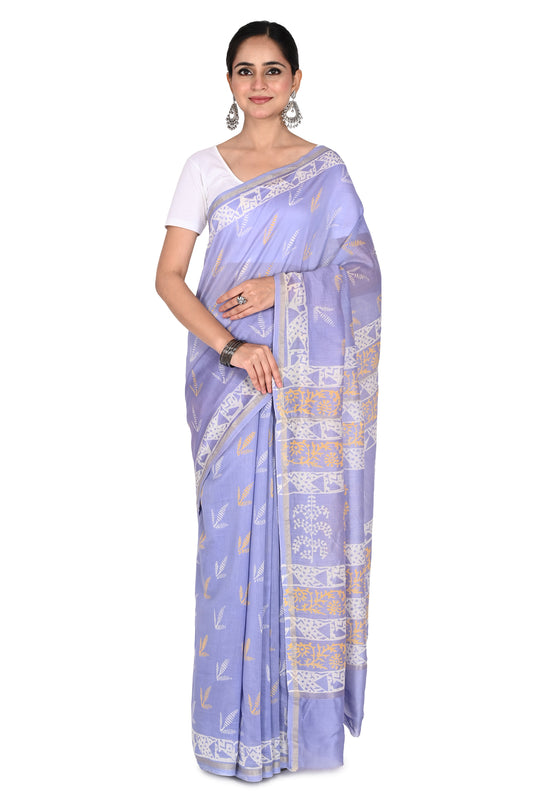 A model wearing the lavender-purple Amira cotton-silk saree, featuring traditional white hand-block floral prints and a thin gold border, styled with a white short-sleeved blouse by naitri.in