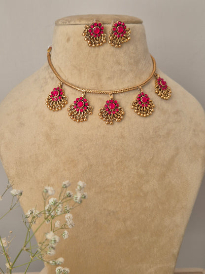Amira gold-plated necklace set with pink stone-studded floral pendants and matching jhumka earrings for ethnic wear by naitri.in