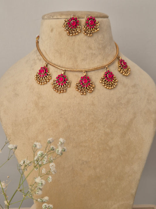 Amira gold-plated necklace set with pink stone-studded floral pendants and matching jhumka earrings for ethnic wear by naitri.in