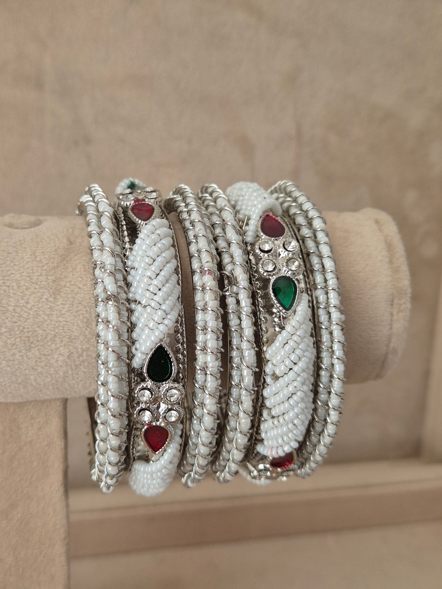 Statement silver bridal bangles with intricate cutout filigree details, a central red gemstone setting, and a textured antique finished by naitri.in