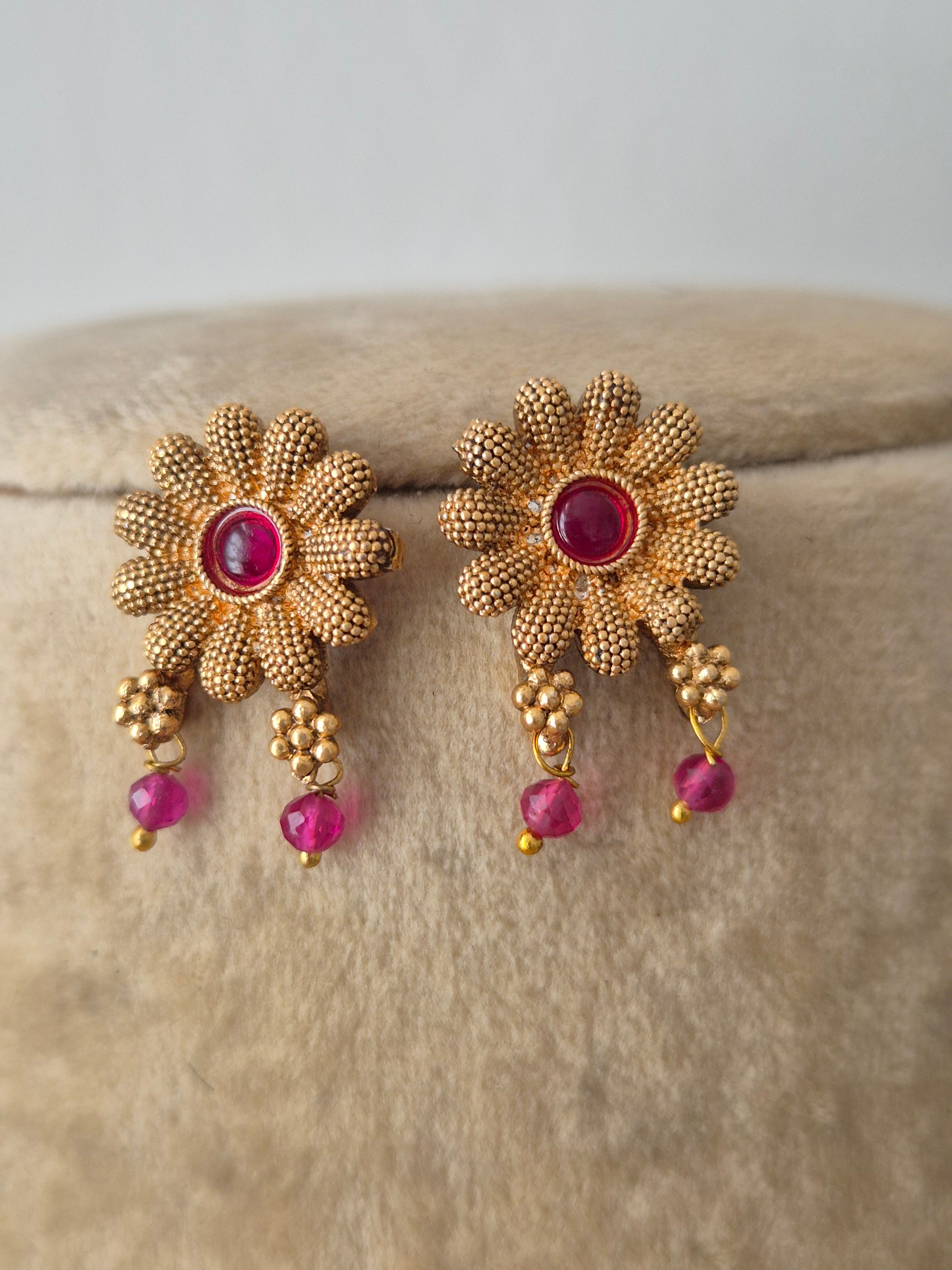 Modern Indian ethnic imitation earrings with vibrant pink-red gemstones  with matching floral-themed earrings by naitri.in