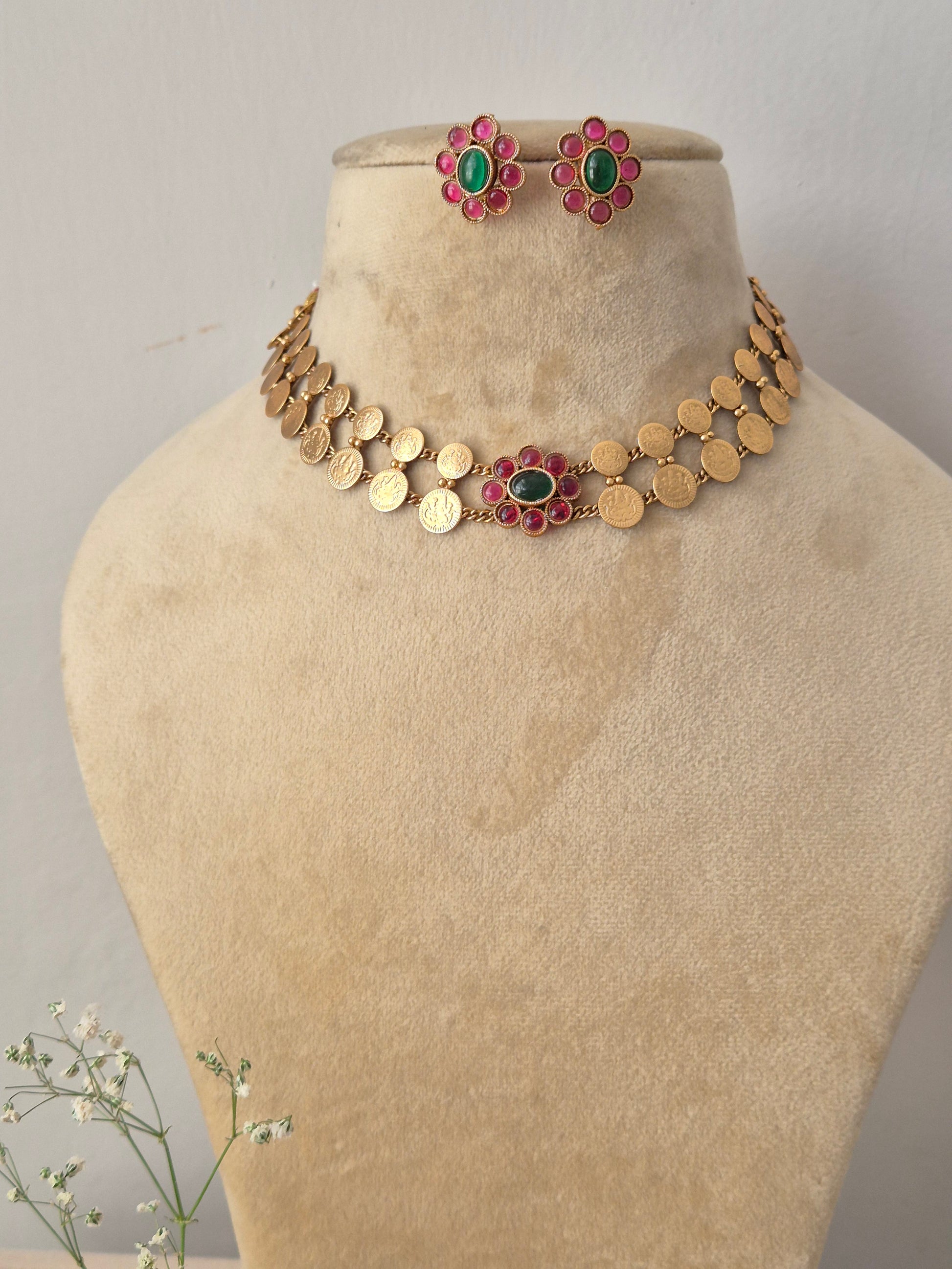 Antique gold choker necklace featuring a central pink and green floral pendant, with matching earrings by naitri.in
