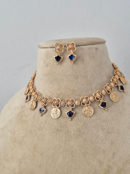 Ornate Designer Charm Necklace and Studs presented on a display bust, emphasizing the refined pendant design, rich metallic finish, and timeless appeal for modern ethnic wear by Naitri.in