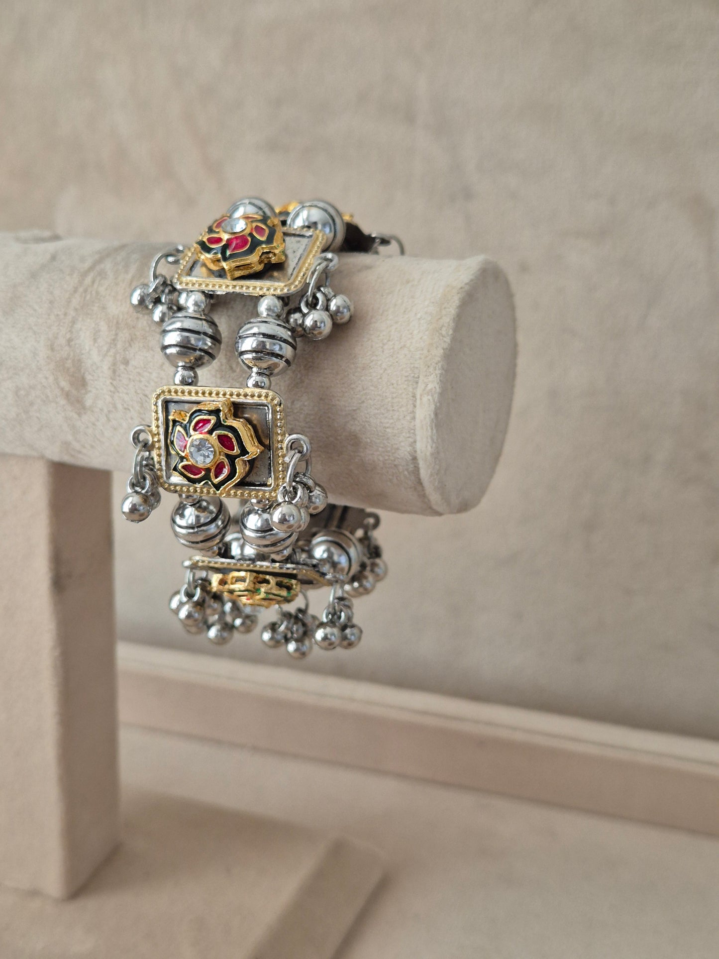 Statement mixed-metal festive Kada bangle featuring intricate rows of silver beads, gold-toned frames, and a hand-painted floral centerpiece by naitri.in
