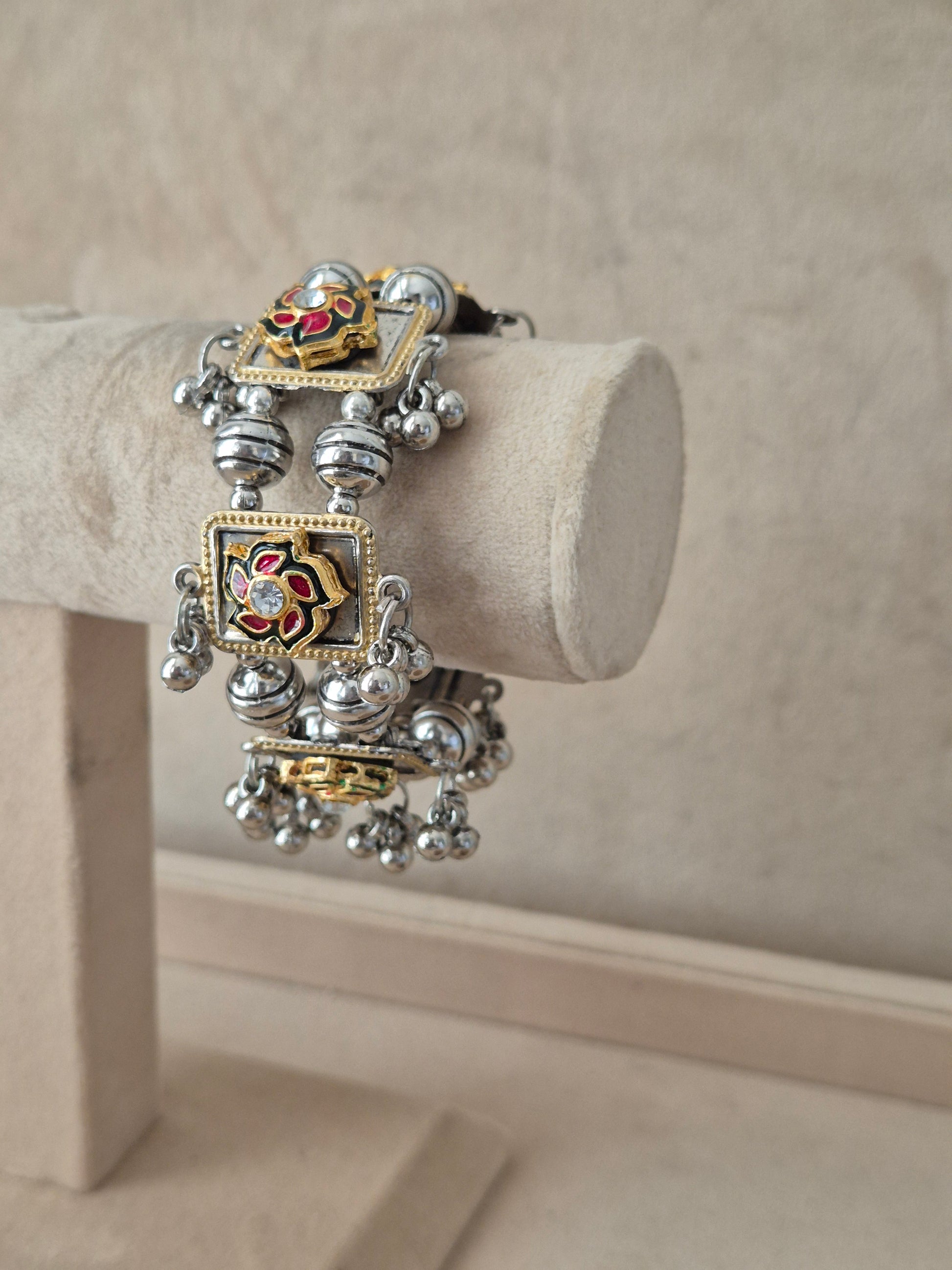 Statement mixed-metal festive Kada bangle featuring intricate rows of silver beads, gold-toned frames, and a hand-painted floral centerpiece by naitri.in