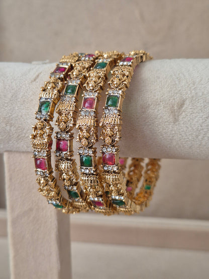 Gold bracelets with gemstones, Festive style golden statement bangles with ethnic gemstone details by naitri.in