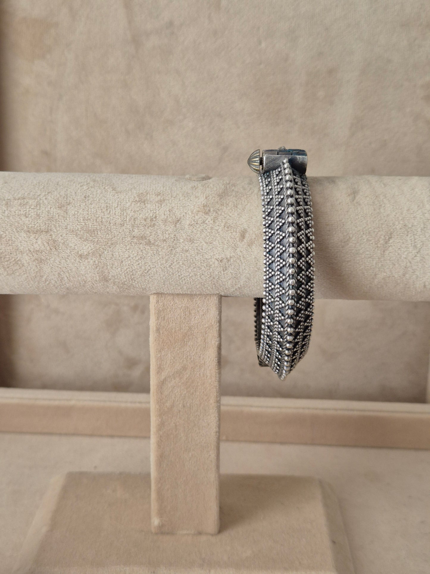 Intricate silver oxidized Ashoki bangle with a textured geometric diamond pattern by naitri.in 