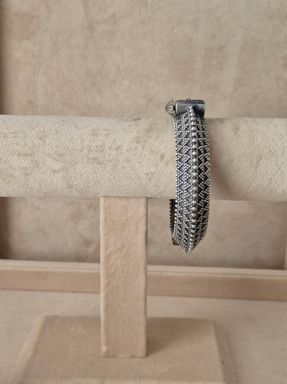 Intricate silver oxidized Ashoki bangle with a textured geometric diamond pattern by naitri.in 